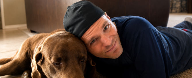 Marty with Bear the chocolate Labrador resting together in their Flagstaff Arizona home.