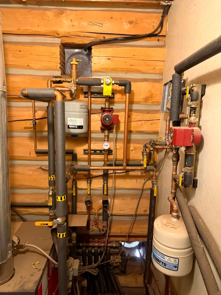 Radiant floor heating manifolds and tubing in a log home mechanical room in Doney Park, Flagstaff, AZ